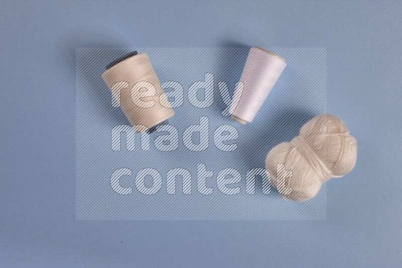 مجموعة من أدوات الخياطة والتفصيل بيضاء اللون على خلفية زرقاء