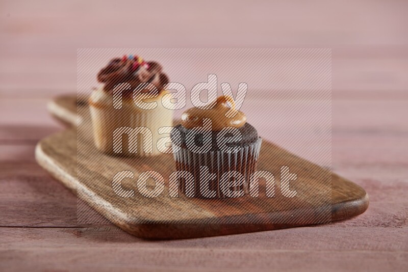 Chocolate mini cupcake topped with peanut butter on a wooden board
