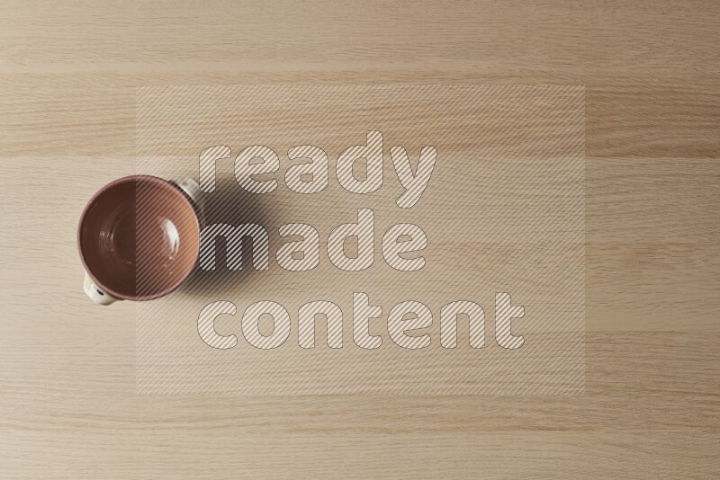 إناء فخاري متعدد الألوان على خلفية خشبية فاتحة