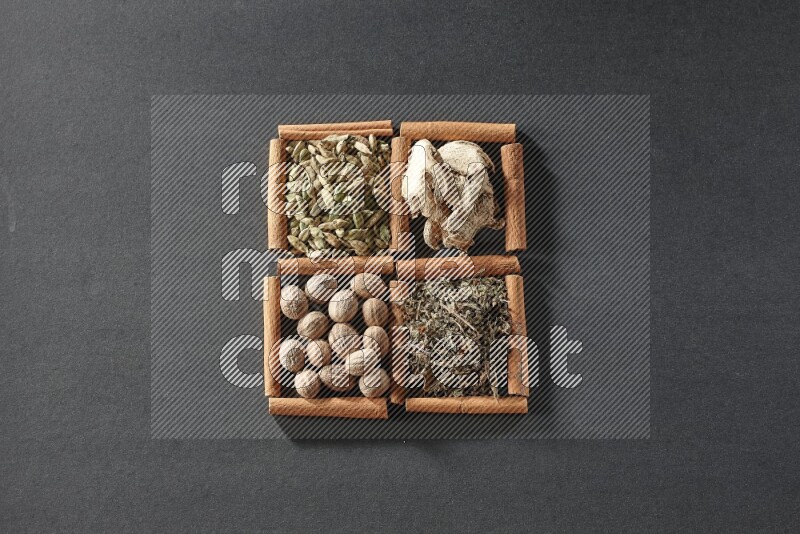 4 squares of cinnamon sticks full of dried basil, cardamom, dried ginger and nutmegs on black flooring