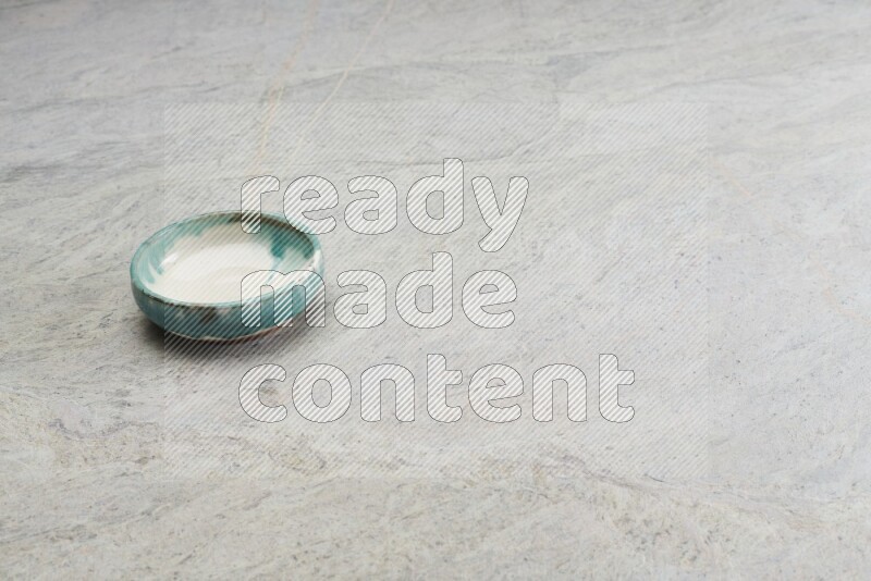 A multicolored pottery bowl on grey marble background