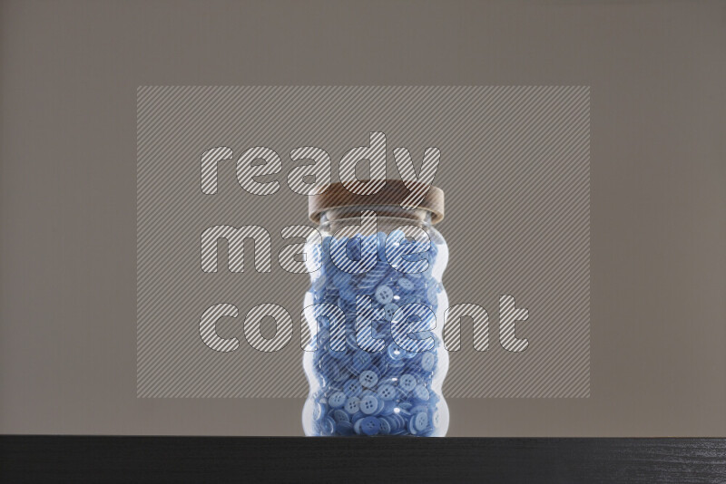 Buttons in a glass jar on black background