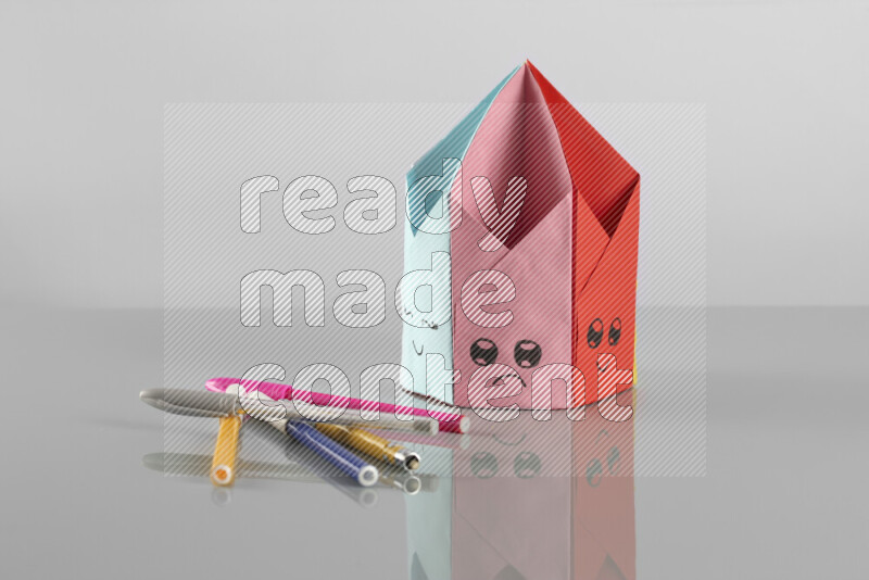 Origami pen holder on grey background