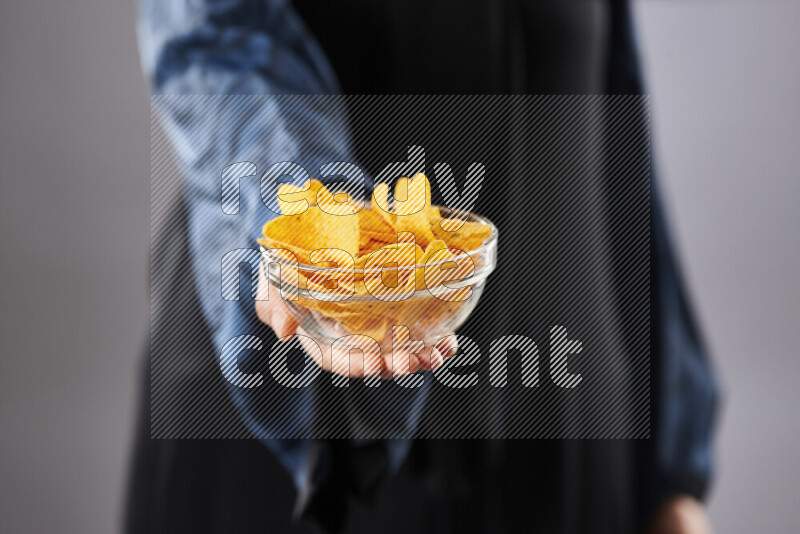 امرأة ترتدي عباءة تحمل أنواع مختلفة من الوجبات الخفيفة في أوضاع متعددة