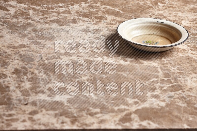 A vintage metal plate on beige marble background