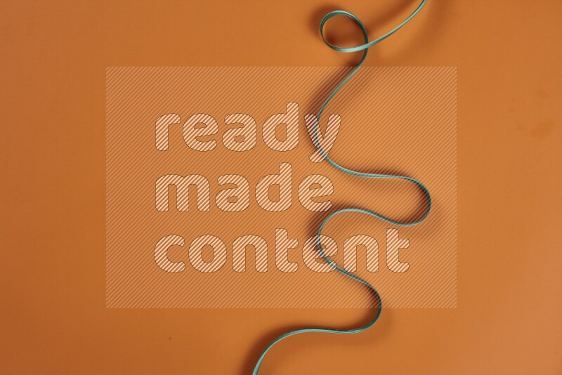 A green and orange collection of sewing and tailoring tools arranged on a orange background