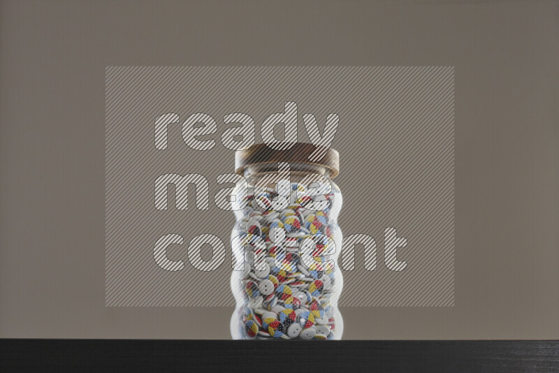 Buttons in a glass jar on black background