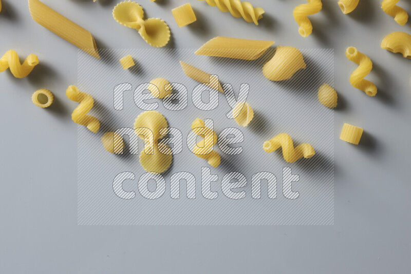 Different pasta types on light blue background