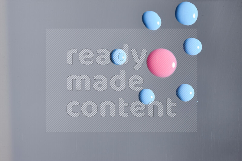 Close-ups of abstract pink and blue paint droplets on the surface