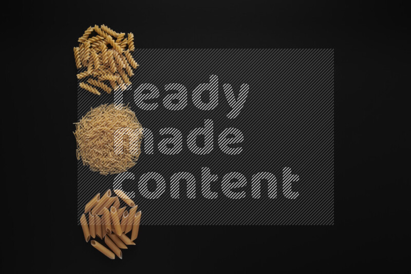 Different pasta types in 3 bunches on black background