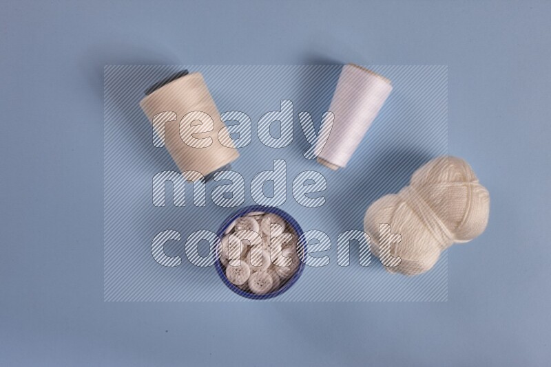 A white collection of sewing and tailoring tools arranged on a blue background