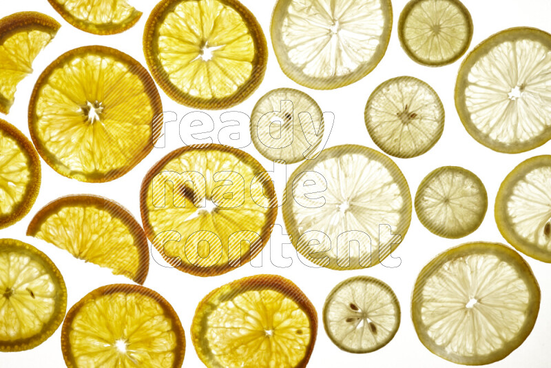 Mixed vegetables and fruits slices on illuminated white background