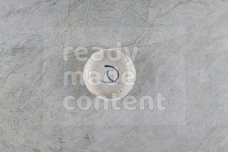 A white pottery bowl on grey marble background