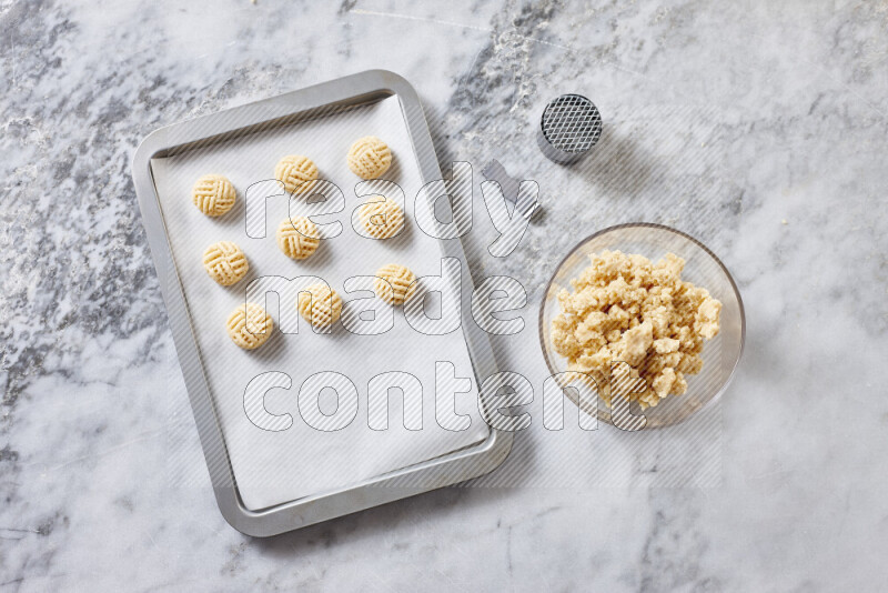 Kahk step by step with its ingredients ghee, sugar, flour, sesame, yeast, water and kahk flavor on grey marble background