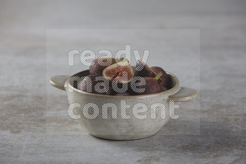 Fresh figs in a bowl on textured grey background
