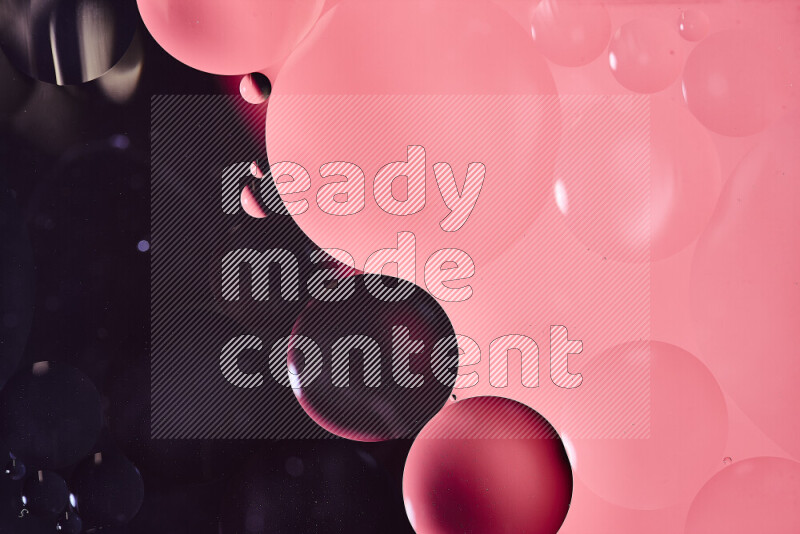 Close-ups of abstract oil bubbles on water surface in shades of black and pink