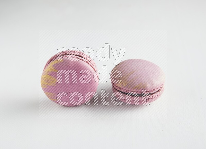 45º Shot of two Purple Strawberry macarons on white background