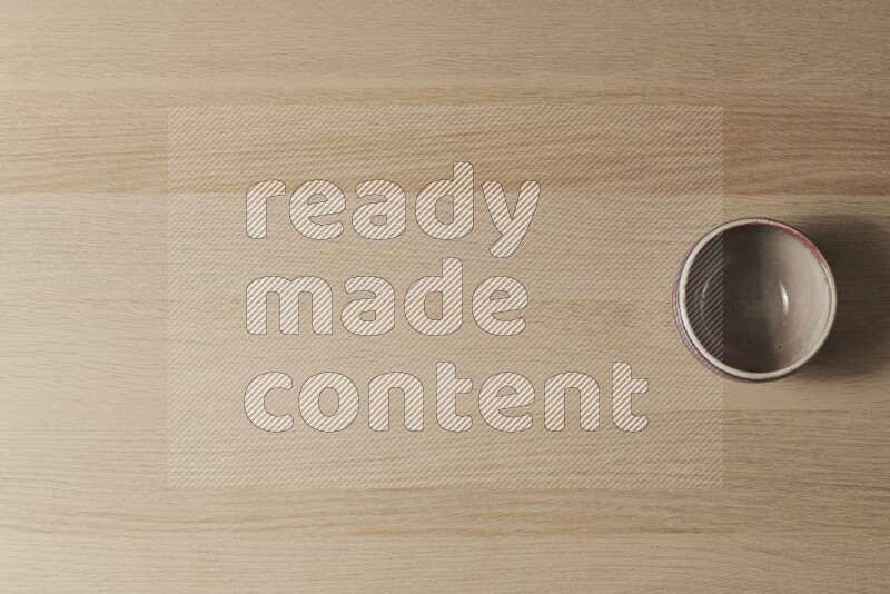 A multicolored pottery bowl on light wooden background