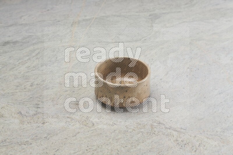 A multicolored pottery bowl on grey marble background