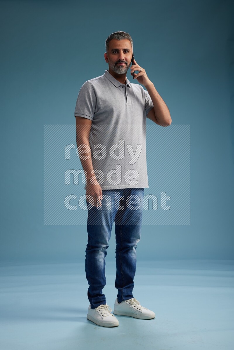 Man Standing talking on phone on blue background