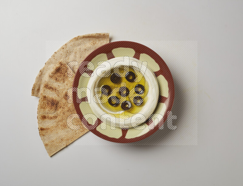 Lebnah garnished with sliced olives in a traditional plate on a white background