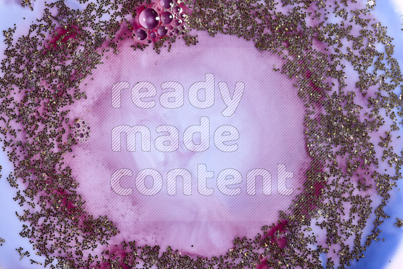 لقطة مقربة لبريق ذهبي متلألئ منتشر على خلفية من اللون الأزرق والأحمر في حركات دائرية