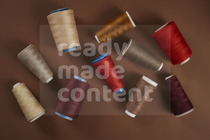 A red collection of sewing and tailoring tools arranged on a brown background