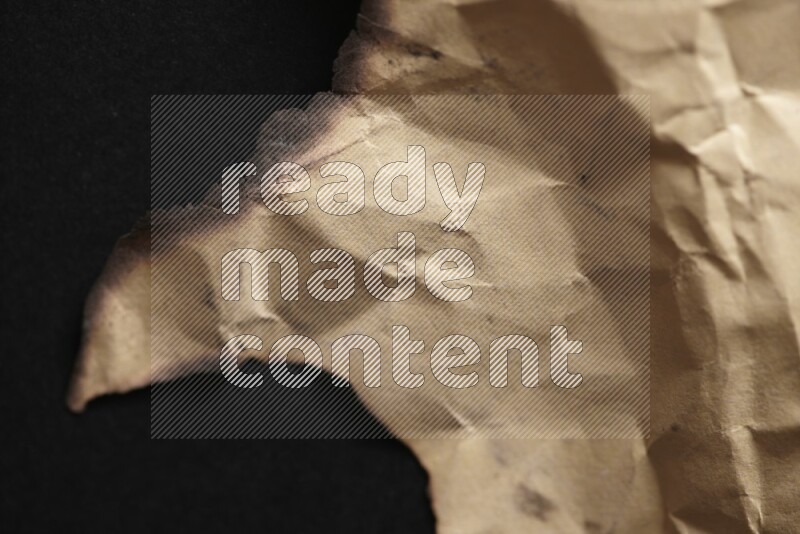 Burnt multicolored paper on black background