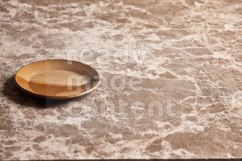 A multicolored pottery plate on beige marble background