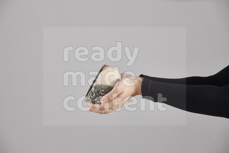 A woman in black abaya holding different pottery essentials in different positions