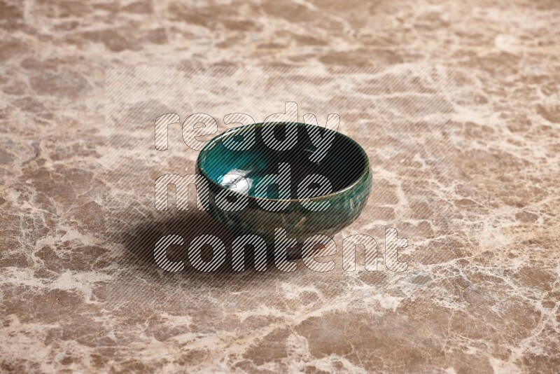 A dark green pottery bowl on beige marble background