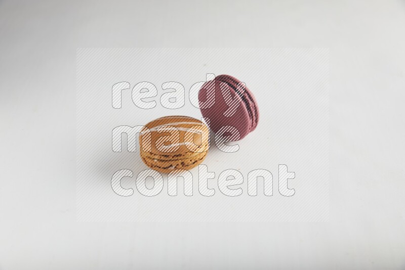 45º Shot of of two assorted Brown Irish Cream, and Red Cherry macarons on white background