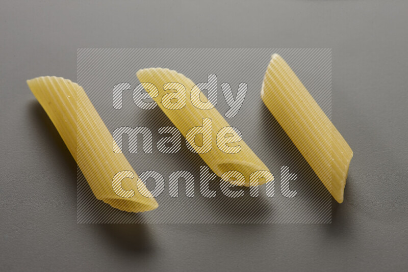 Penne pasta on grey background