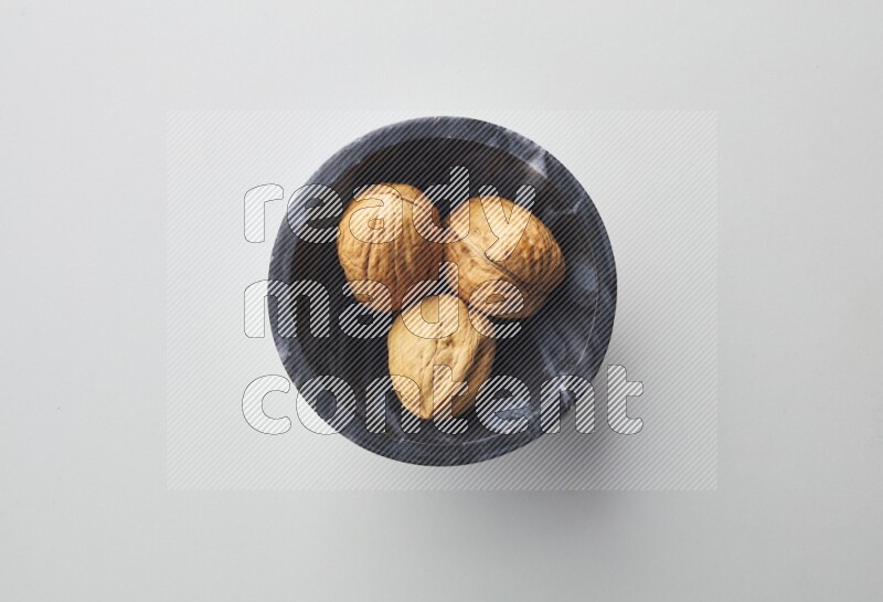 Top-view shot of walnut in a container on white background