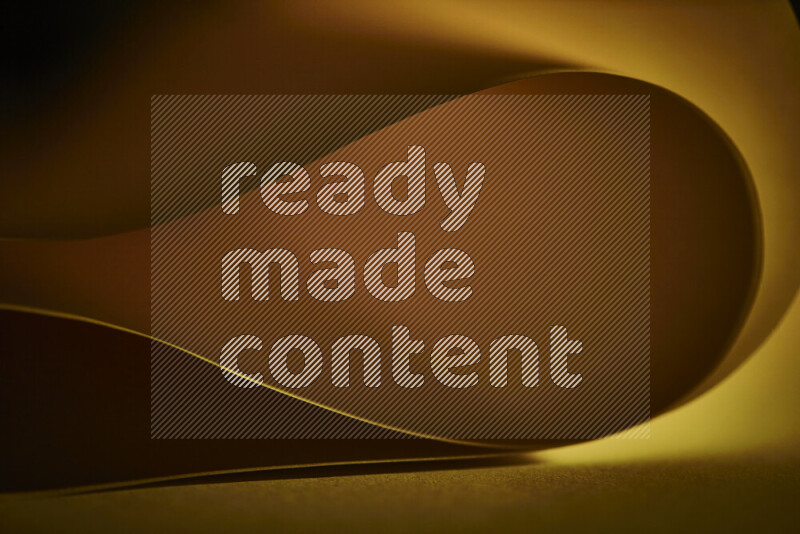 فن تجريدي يعرض منحنيات وتدرجات اللون الأصفر مكونه بضوء ملون