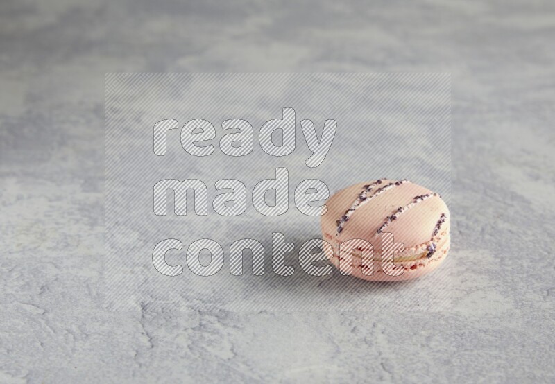 45º Shot of pink orange blossom macaron on white  marble background