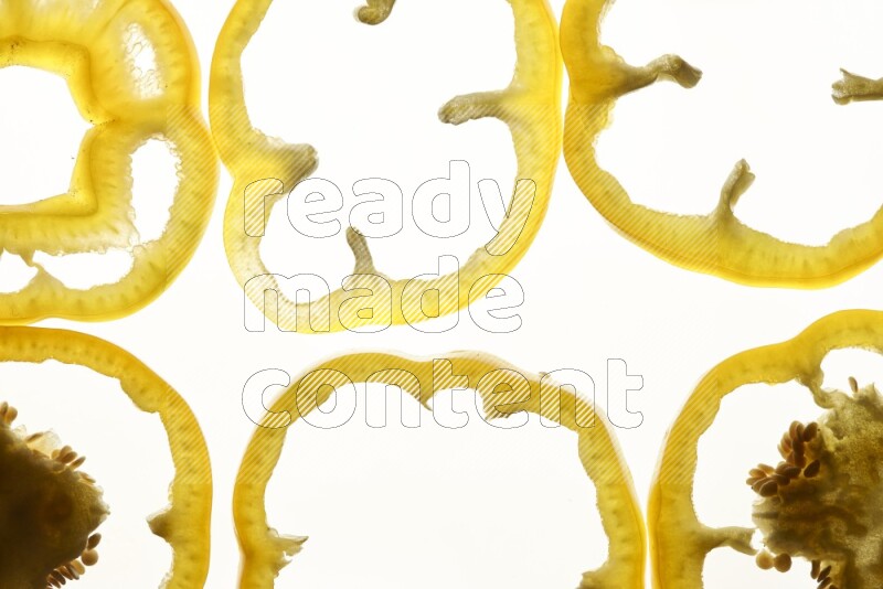 Yellow bell pepper slices on illuminated white background