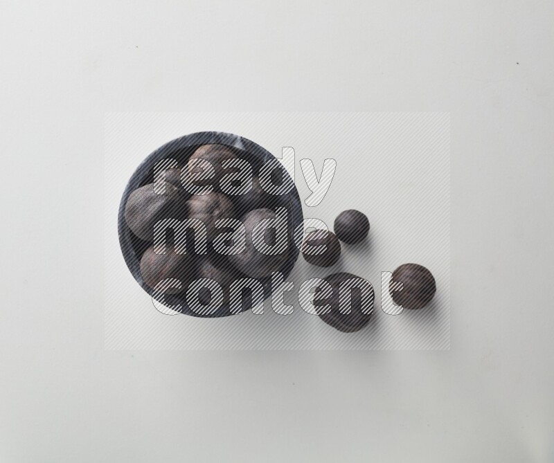 Top-view shot of dried lime (loomi) in a container on white background
