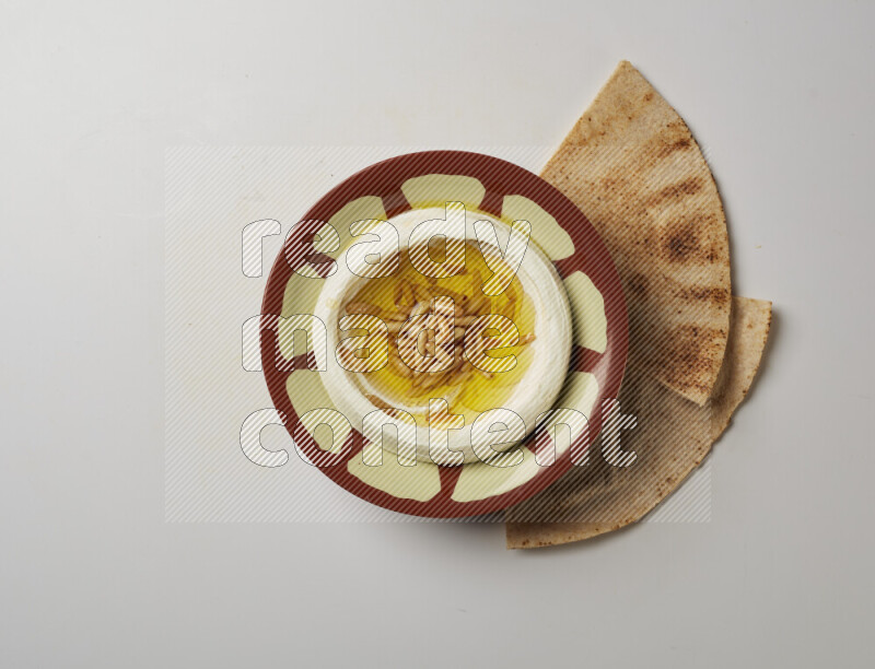 Lebnah garnished with pine nuts in a traditional plate on a white background