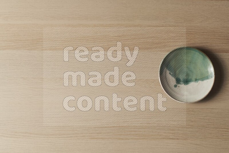 صحن فخاري متعدد الألوان على خلفية خشبية فاتحة