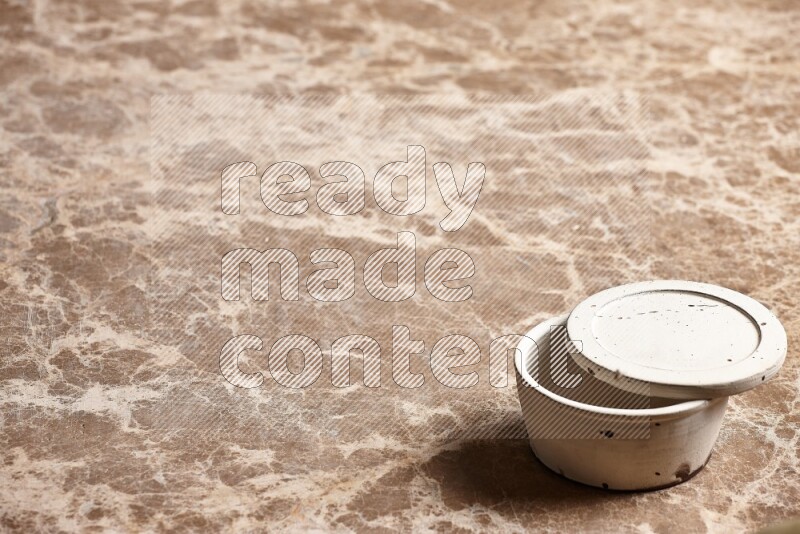 A white pottery bowl on beige marble background