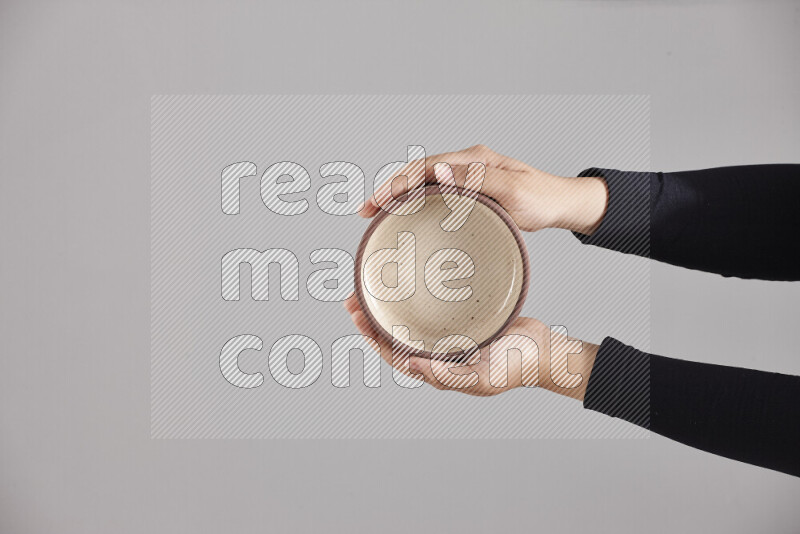 A woman in black abaya holding different pottery essentials in different positions
