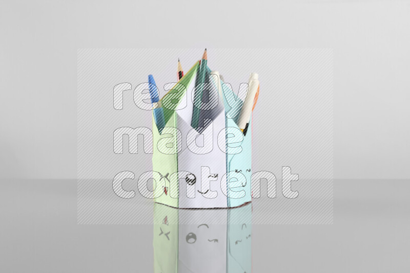 Origami pen holder on grey background