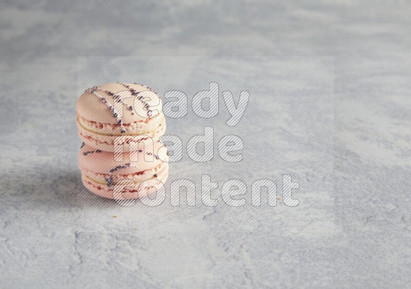 45º Shot of two pink orange blossom macarons  on white  marble background