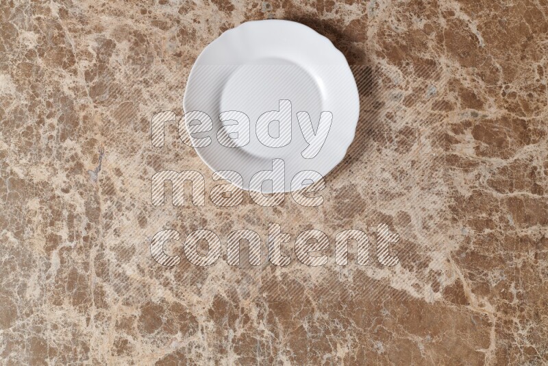 Top View Shot Of A White Ceramic Circular Plate On beige Marble Flooring