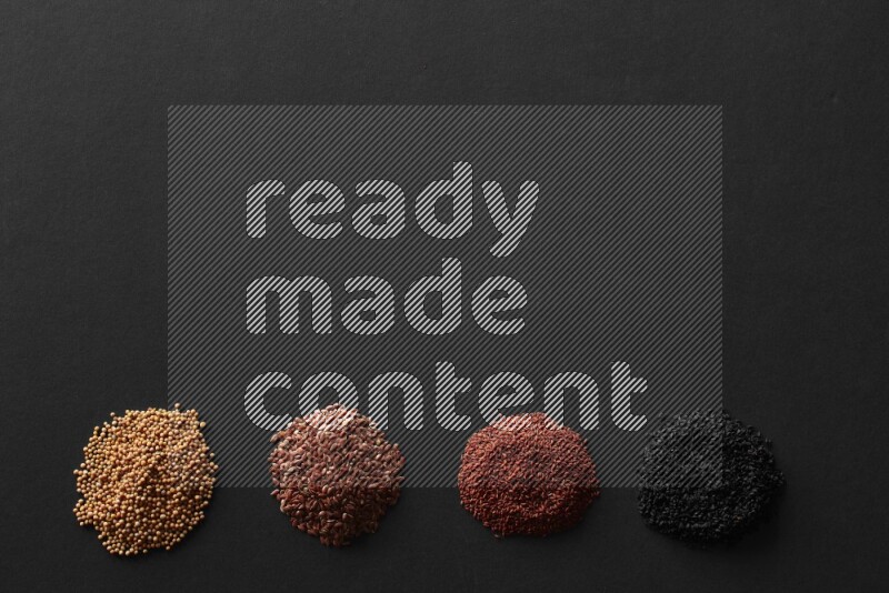 Black seeds, mustard seeds, garden cress and flax on a Black background