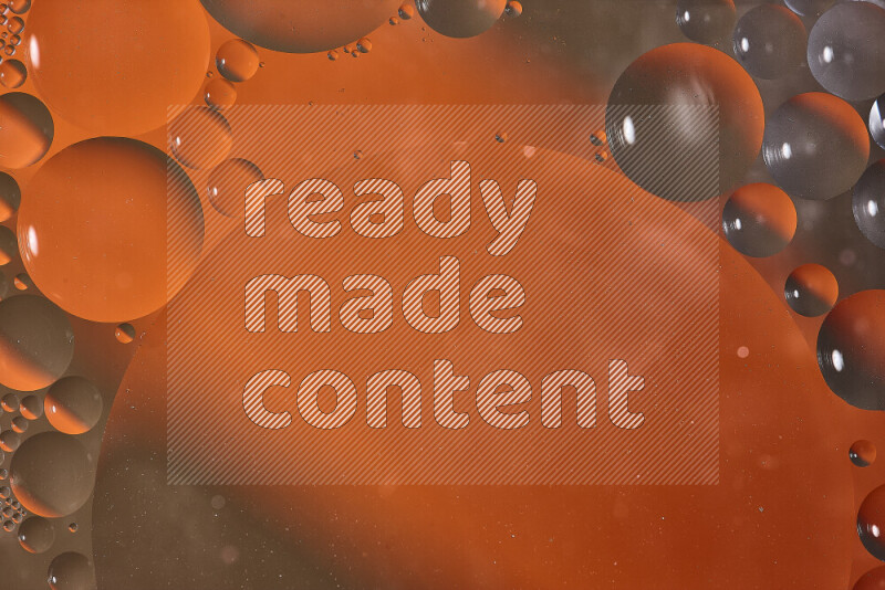 Close-ups of abstract oil bubbles on water surface in shades of orange and brown