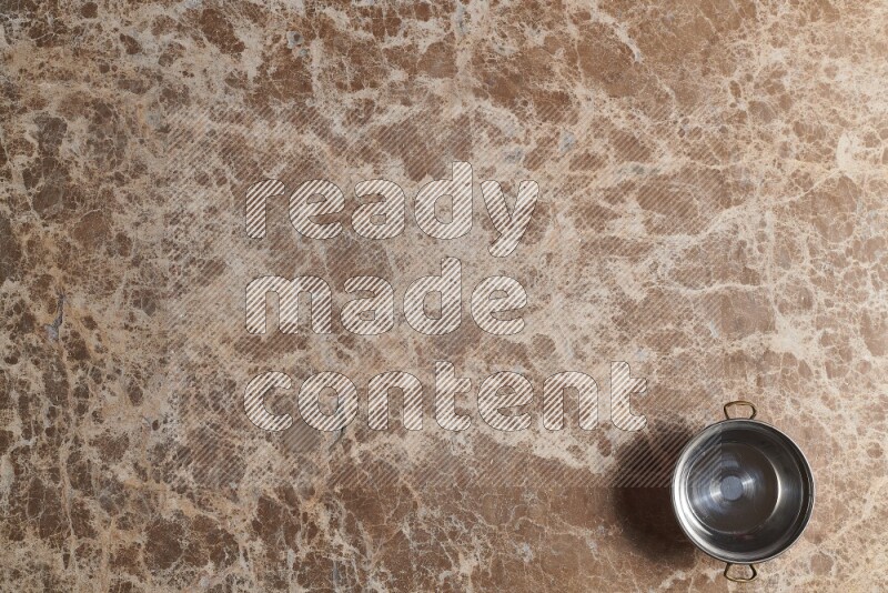 A small copper pot on beige marble background