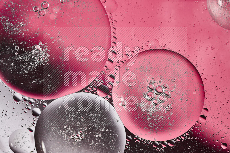 Close-ups of abstract oil bubbles on water surface in shades of white and pink
