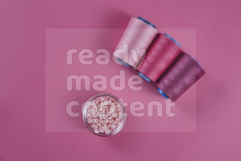 مجموعة من أدوات الخياطة والتفصيل زهرية اللون على خلفية زهرية